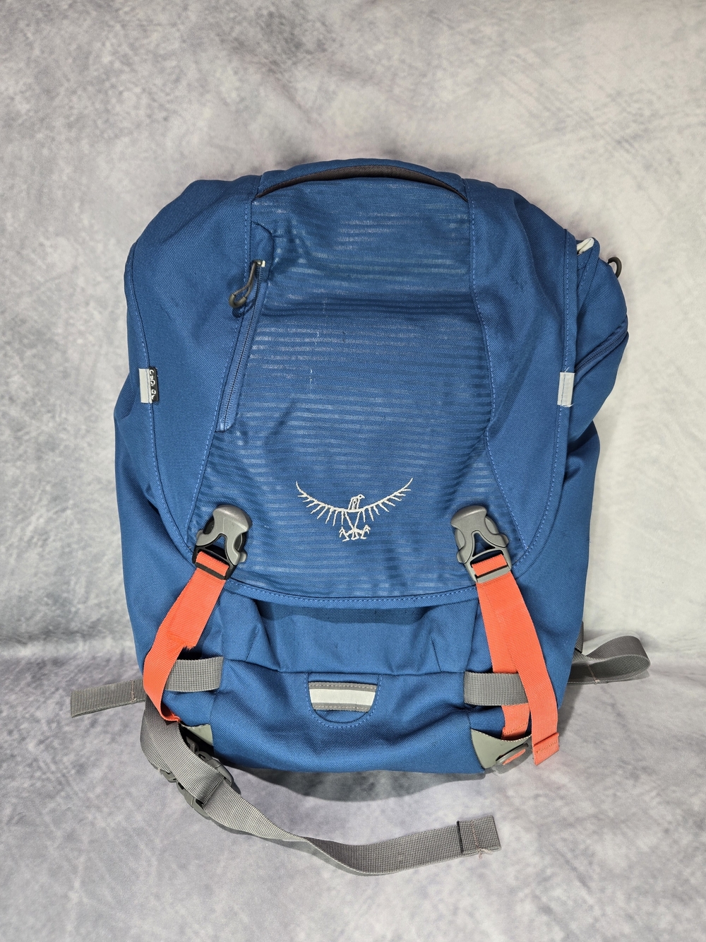 Osprey FlapJack Pack in a blue colorway with bright orange buckle straps